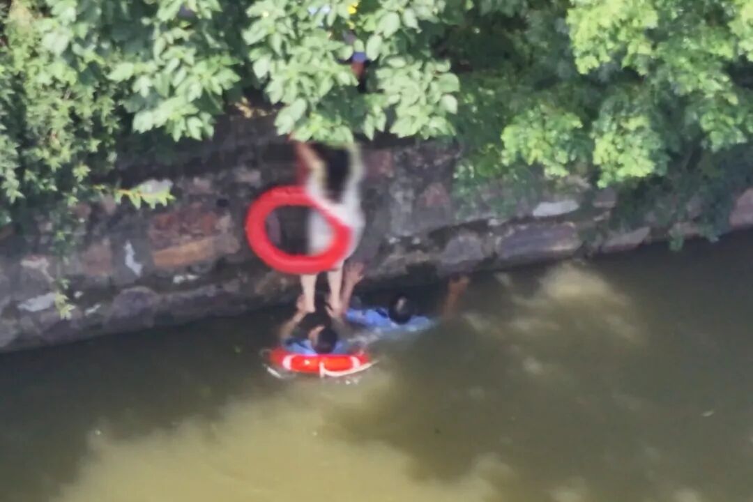 面对落水女子 他们一跃跳入河中